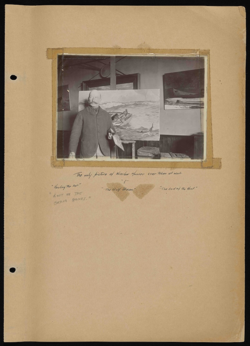 A page of a historical scrapbook showing a photograph of artist Winslow Homer