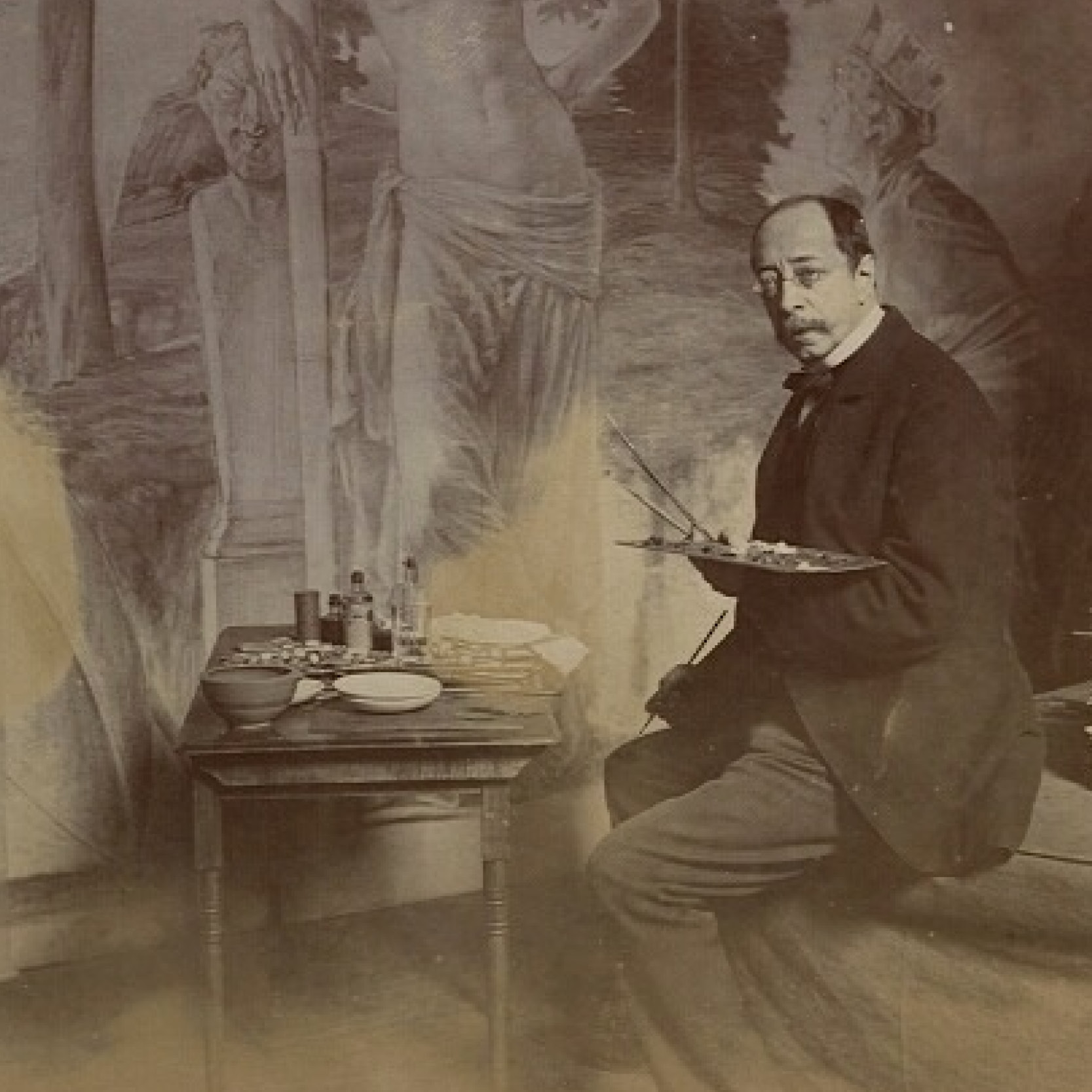 A 19th-century photograph of an artist working on a mural in his studio