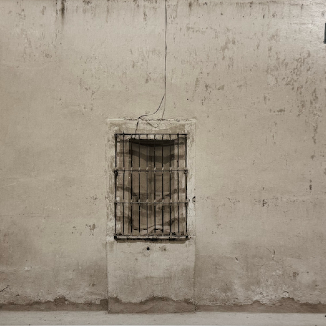 A black and white architectural photo of a barred window