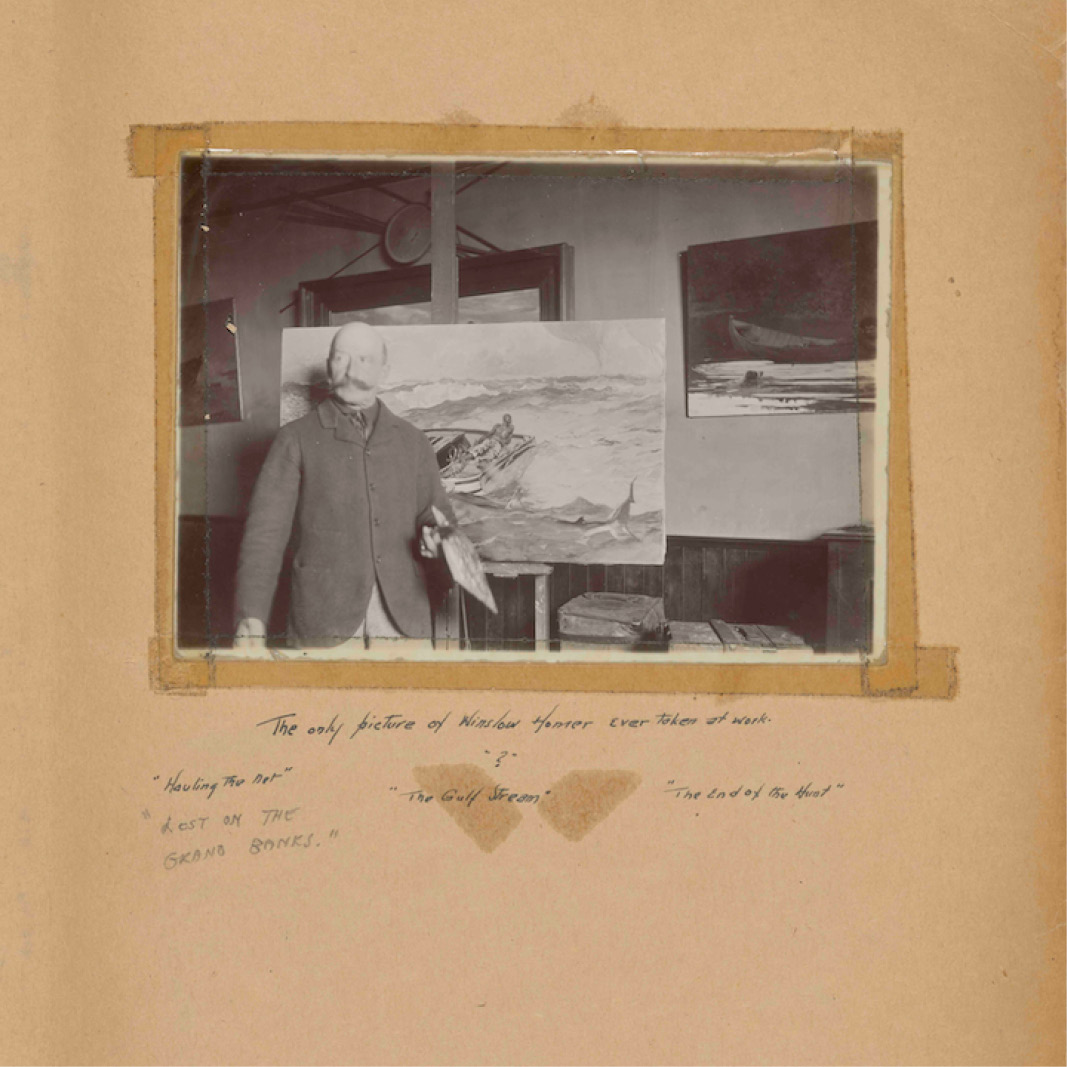 A page of a historical scrapbook showing a photograph of artist Winslow Homer
