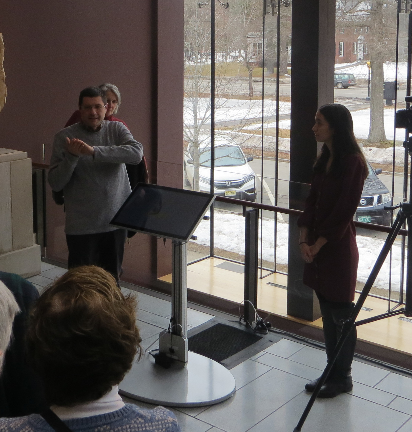 A person speaking to a group in an art museum exhibition