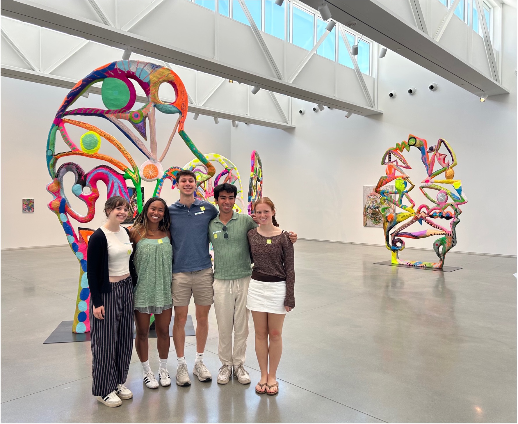 Five student interns pose in a gallery