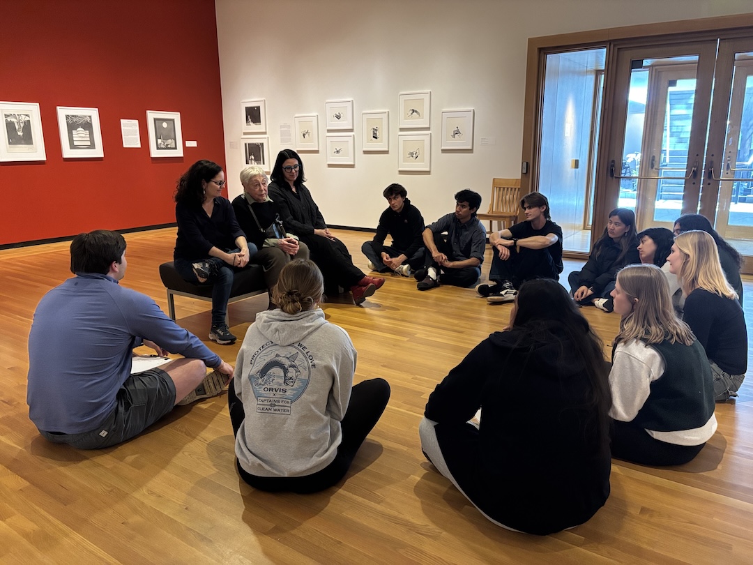 A class sits in a circle in an art museum gallery