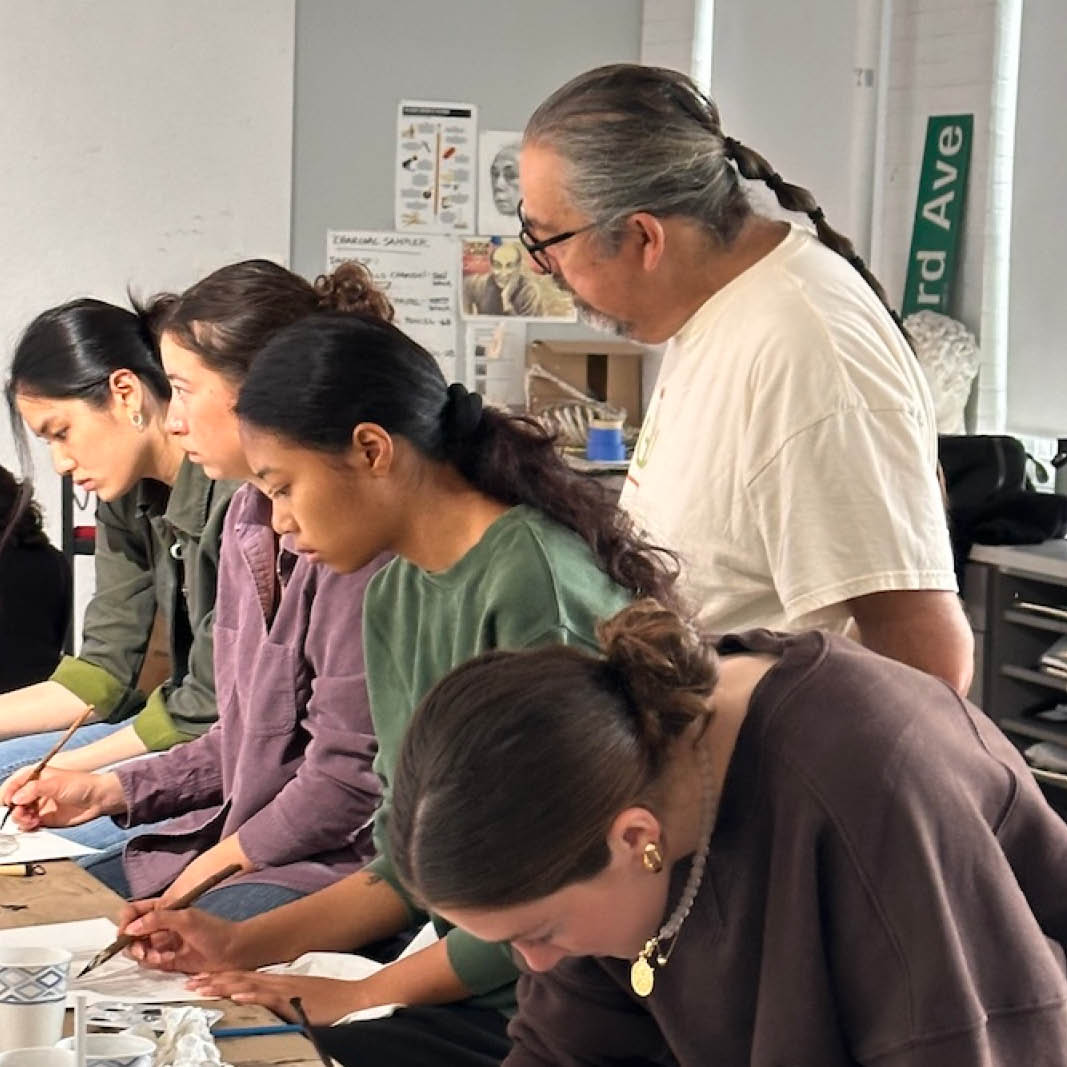 An artist guides students in a college art class