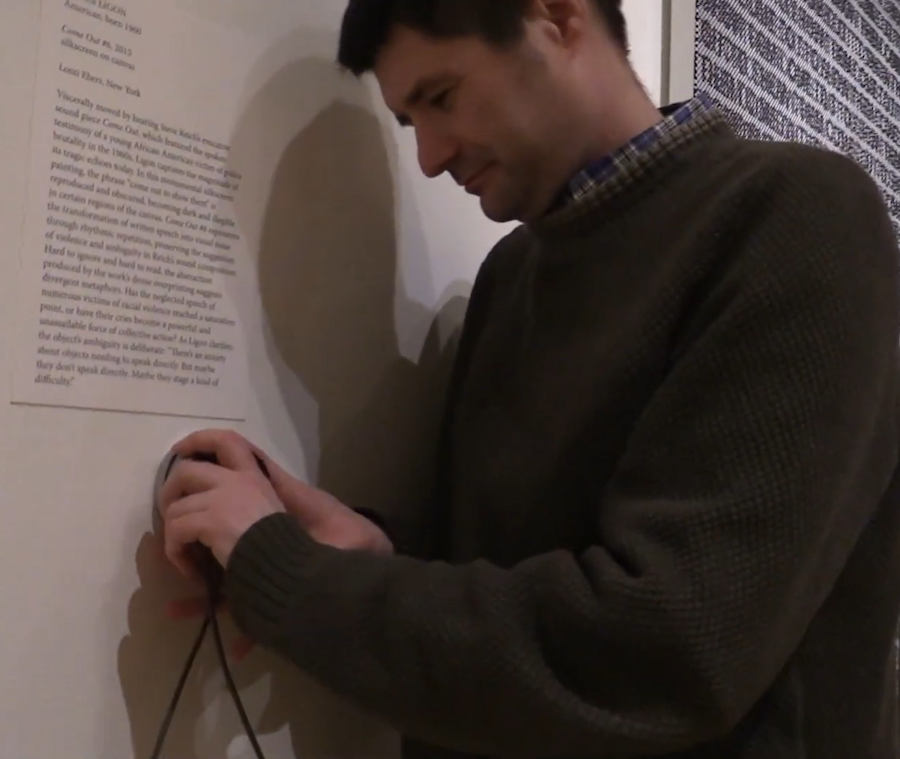 A person installs technology in a museum exhibition