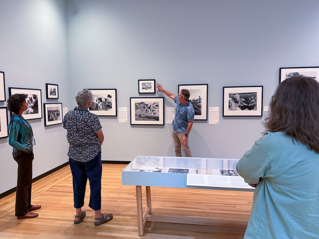 A professor leads a tour of an exhibition of photography