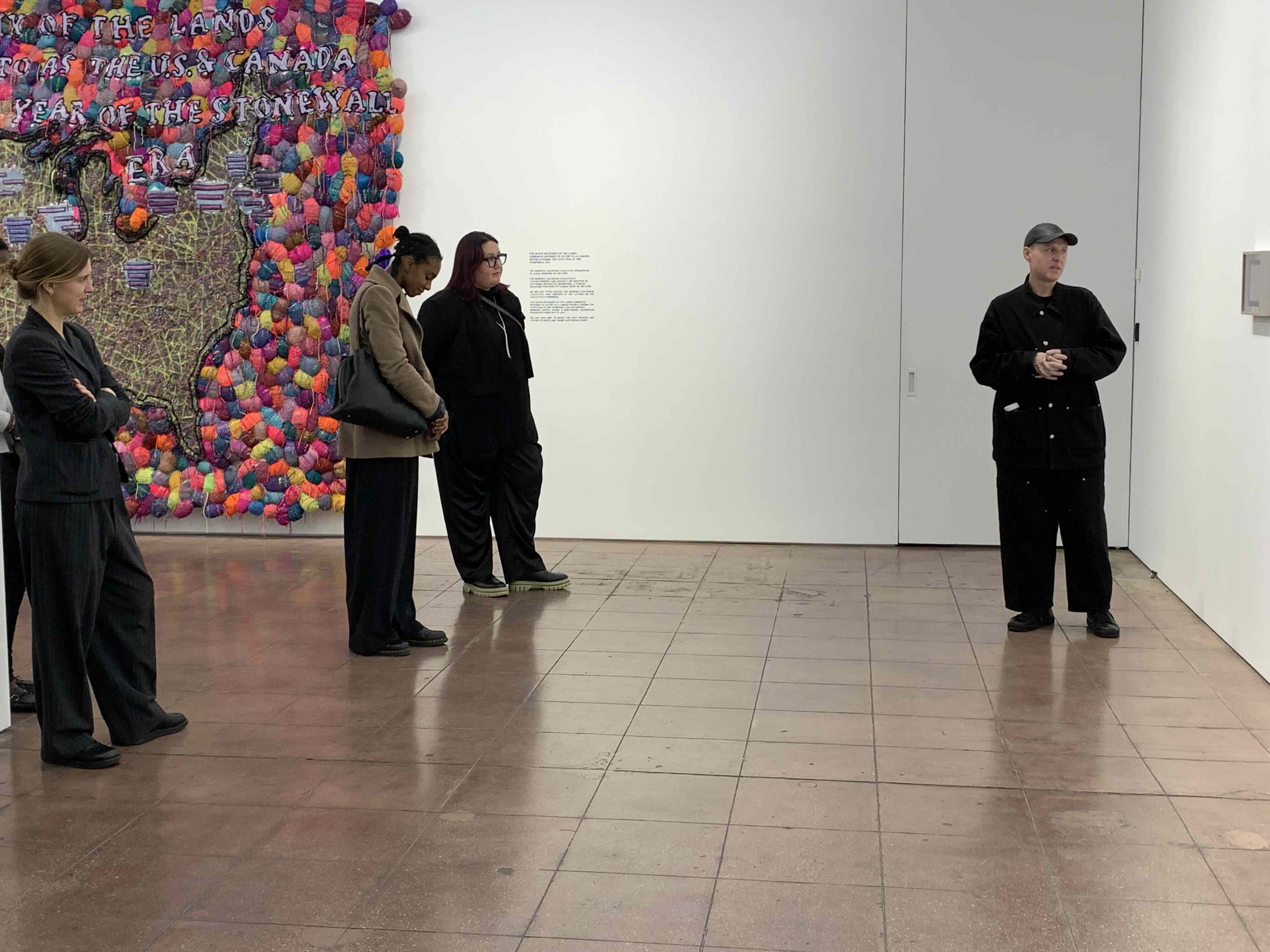 People listen to an artist speak about their work