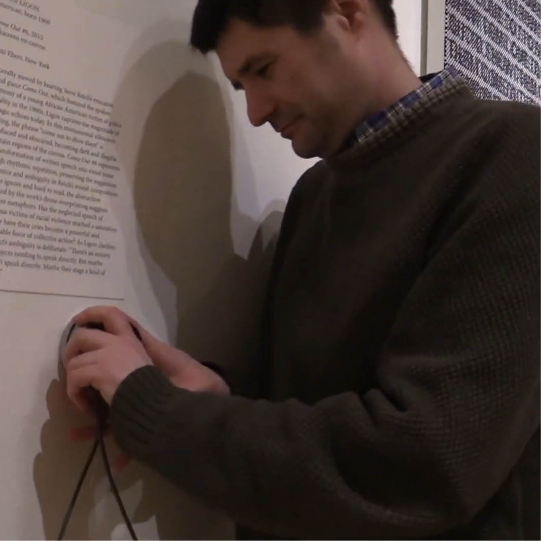 A person installs technology in a museum exhibition