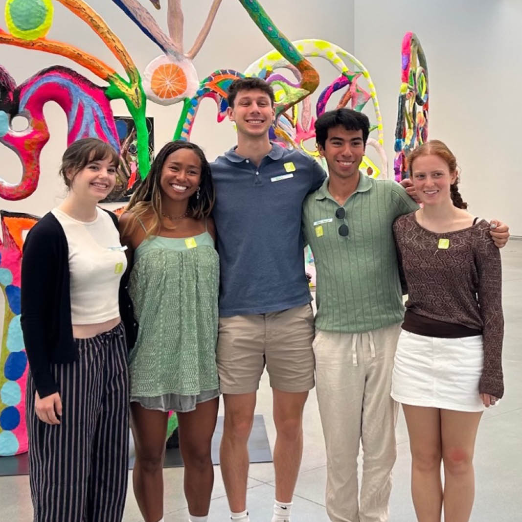 Five student interns pose in a gallery