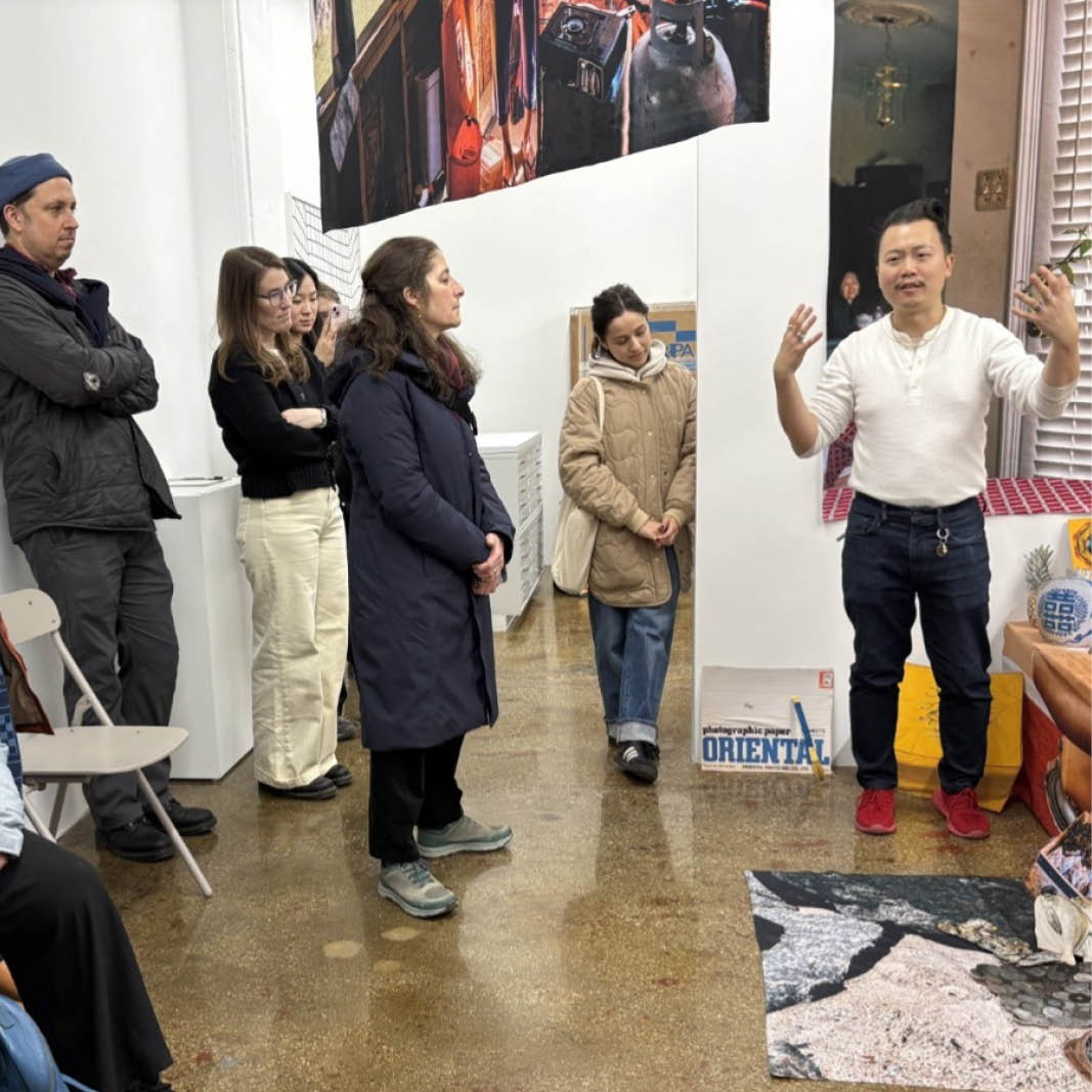 People listen to an artist speak about their work