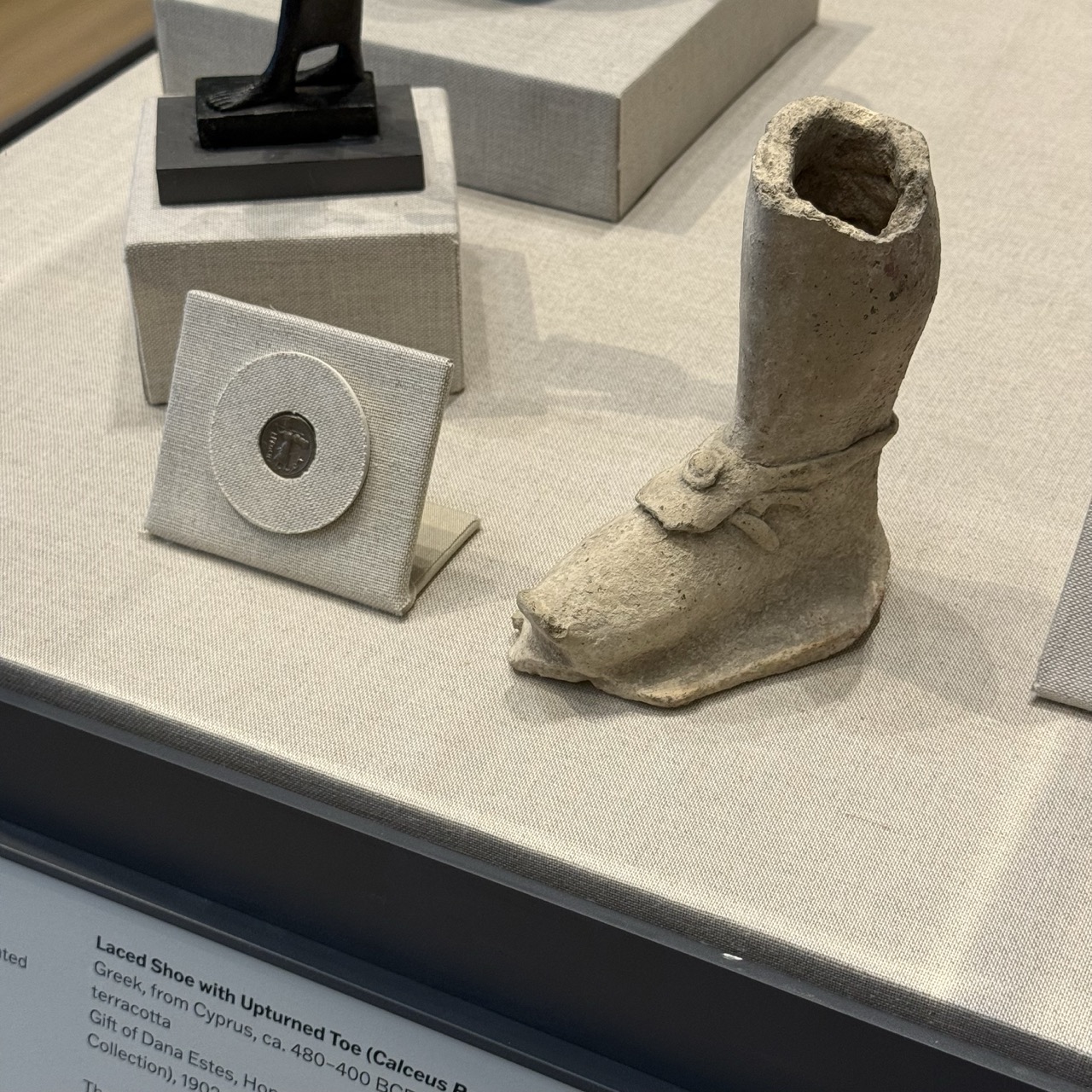 An ancient coin and fragment of a terracotta sculpture