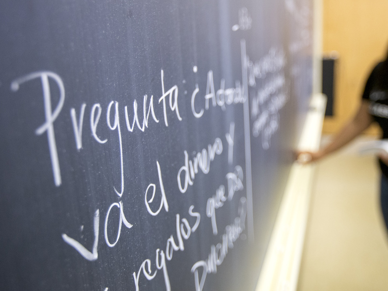 Faculty member writing on a chalkboard during a class.