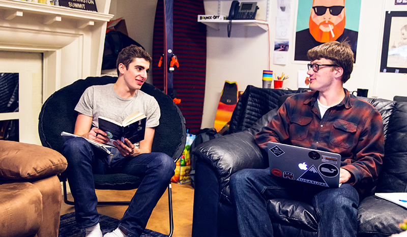 Students study and talk in a college house room.