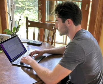 Adam works on his computer to analyze data from the plant.