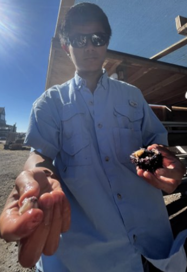 Aden holds a sea urchin in hand while posing for the camera.