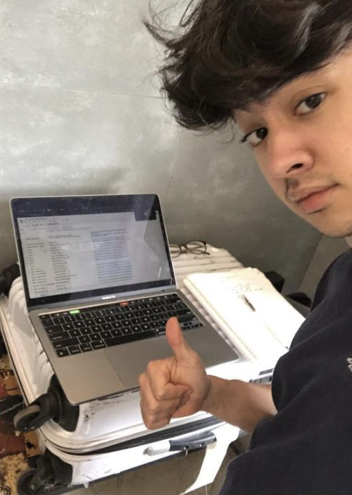 Alexander poses with their work on their laptop.