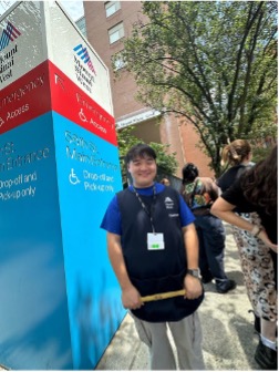 Andrew Train standin in front of Mount Sinai sign