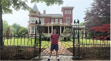 Andy Robinson posing in front of a house