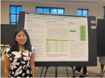 Anna-Li Bateman standing in front her poster