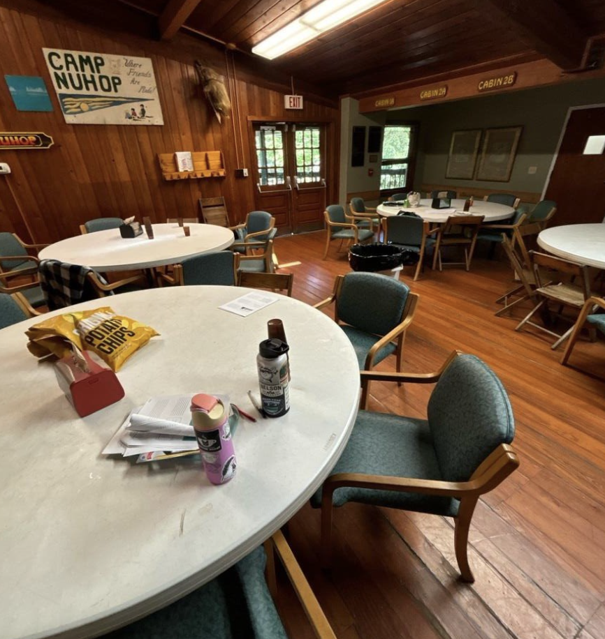 A photo of an indoor space with a sign that reads "Camp Nuhop" in the background.