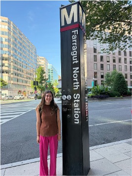 Avery Cutler standing next to a sign for a public transportation stop