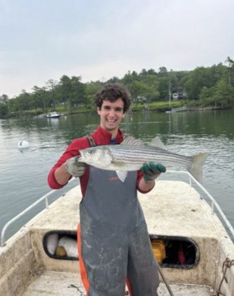 Brendan on a boat holding a fish.