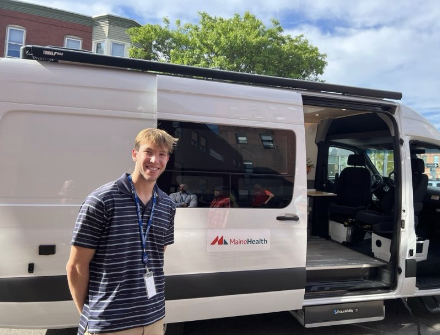 Cole poses next to a MaineHealth van.
