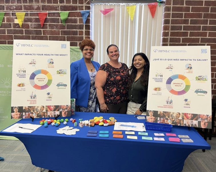 Gisela pictured with co-workers while working at Healthcare Foundation of Northern​ Lake County's table. 