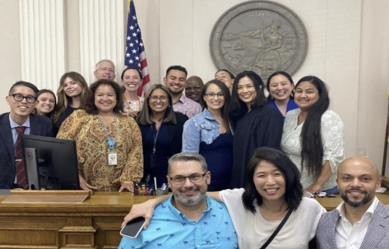 Grace poses with fellow interns and members of their team in a courthouse.