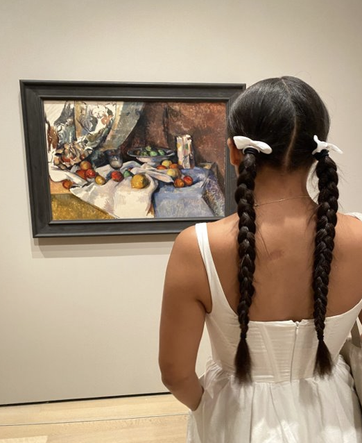 Isabella's back profile as they study a piece at MOMA.