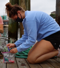 Jess kneeling on a dock