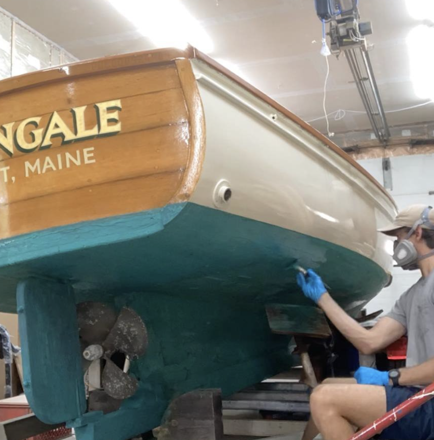Liam works on the bottom of a boat.
