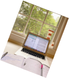 Computer sitting on desk in front of window