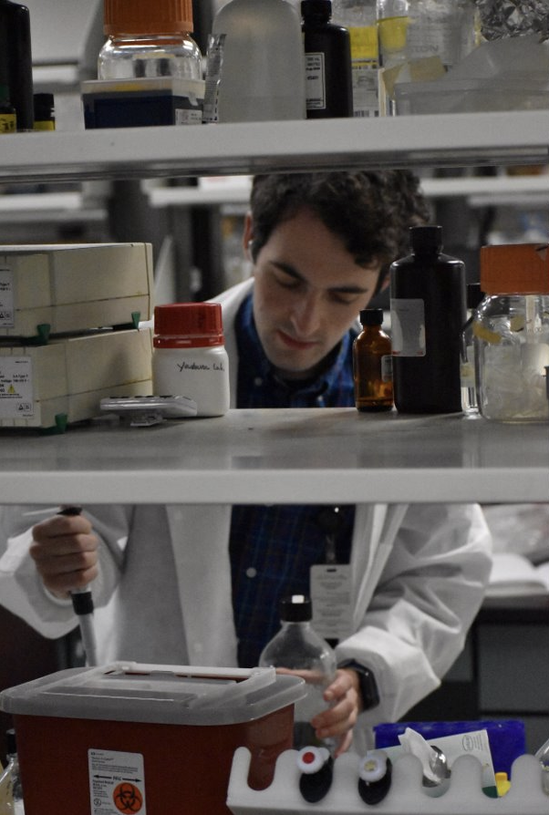 Noah works in the lab, handling various equipment relating to their research.