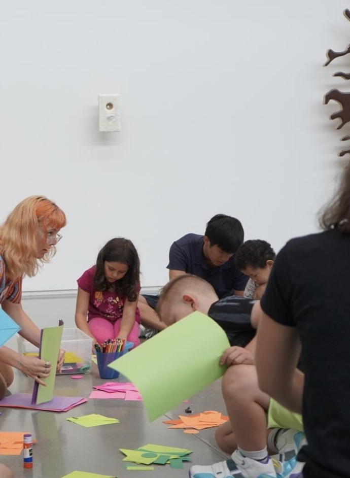Penn and another team member instruct young children with crafts