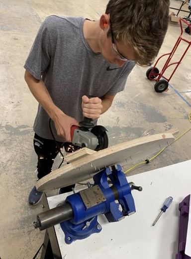 Sam using a power tool to cut wood.