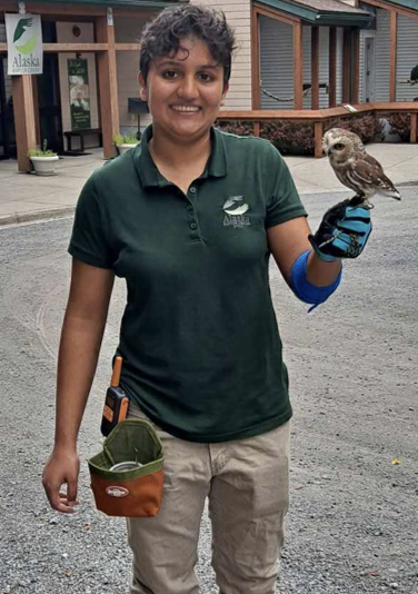 Student poses with bird on hand.