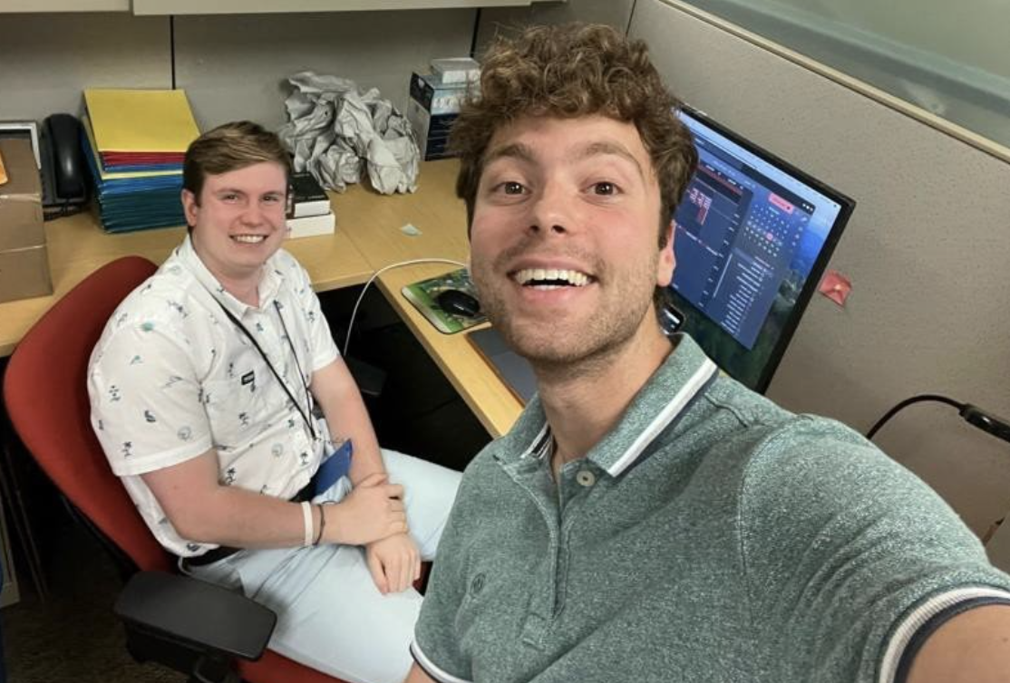 Seth poses with a coworker in the office.