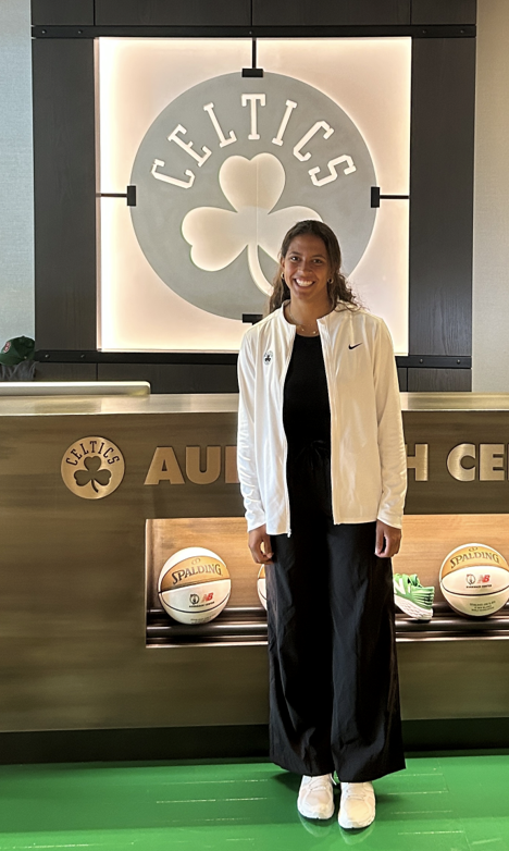 Sydney posing in front of the Boston Celtics sign.