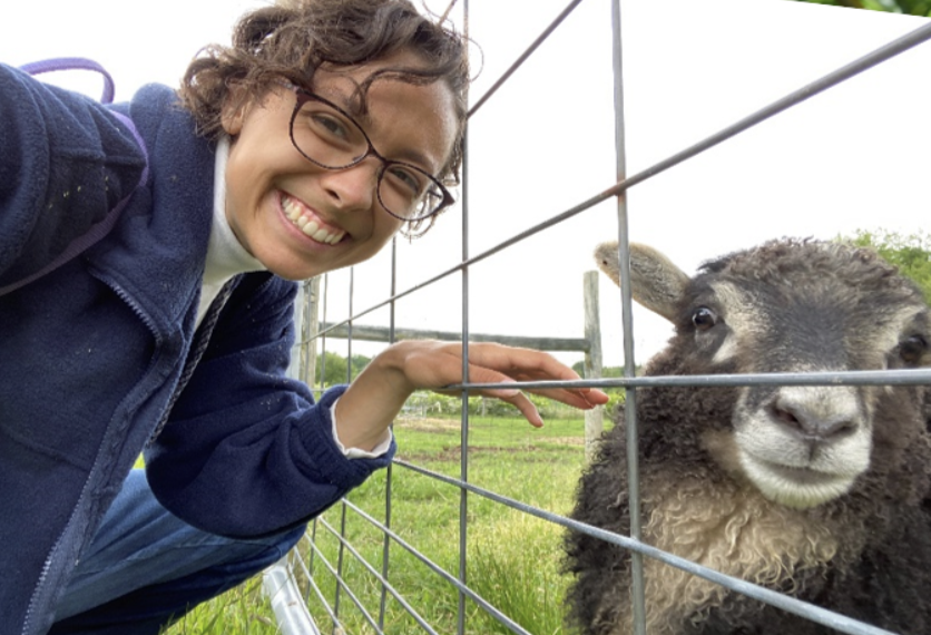Student poses with sheep.