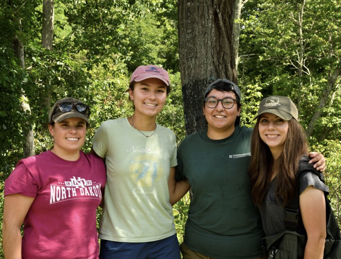 Wren posing with other coworkers in the forest.
