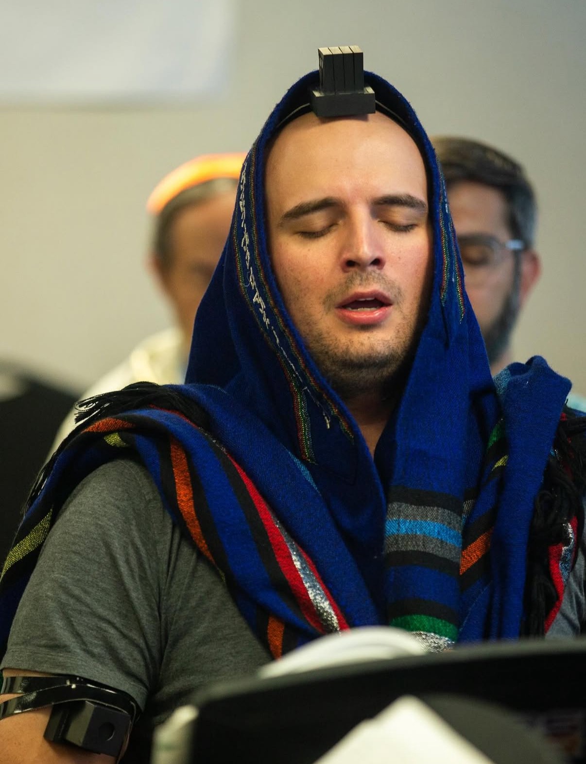 Image of Conner Dedrick with eyes closed and wearing a head covering and tefillin.