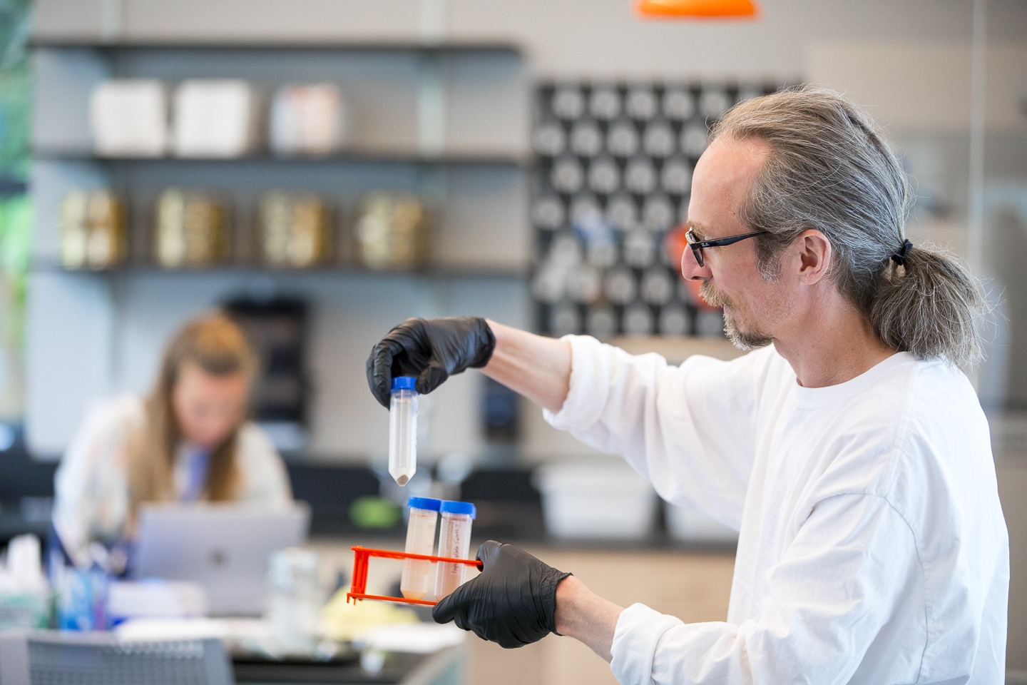 Phil Camill in classroom holding science tube