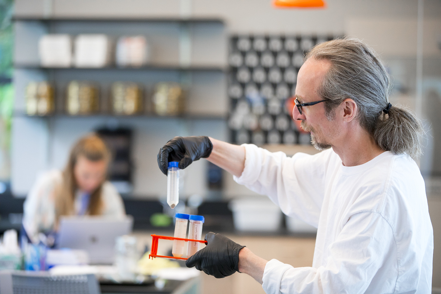 Phil Camill in classroom holding science tube