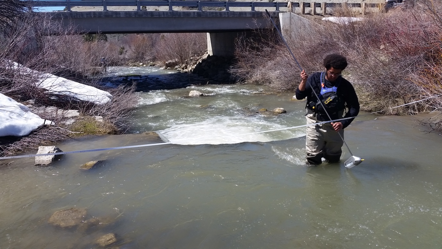 Jabari Jones standing in water collecting samples