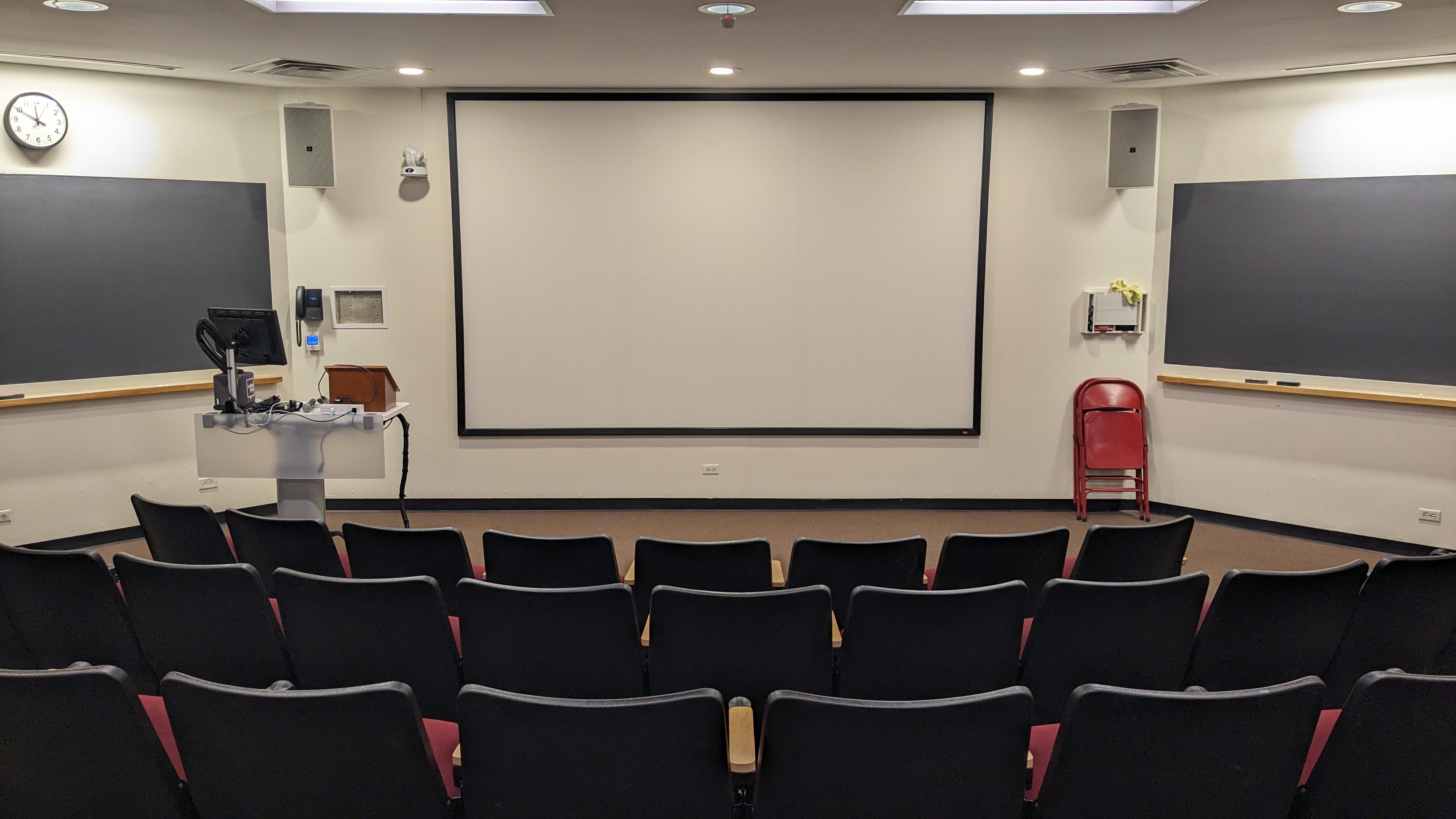 Lecture hall with seats facing large whiteboard