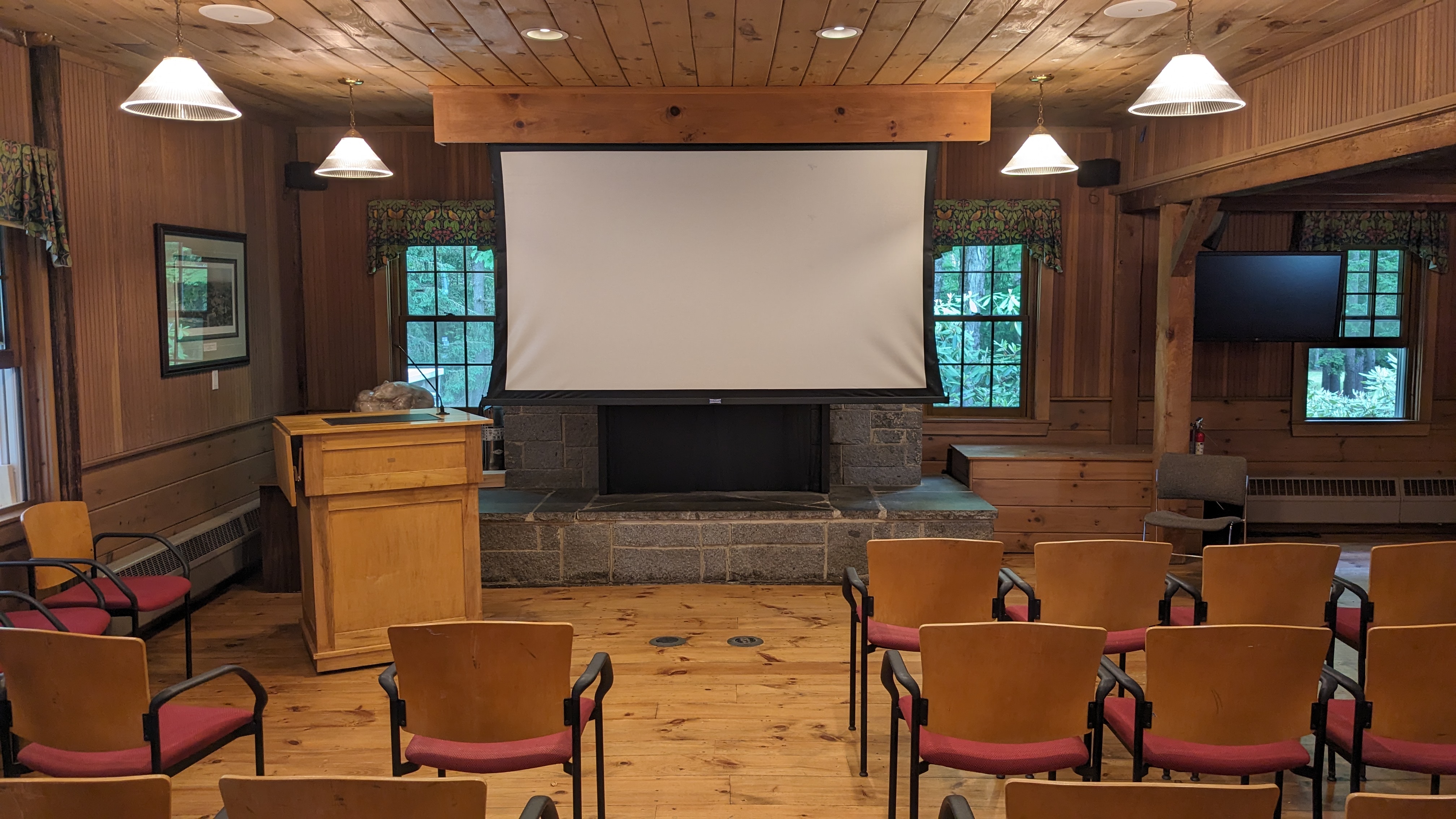 Wooden room with podium and chairs in front of the fireplace