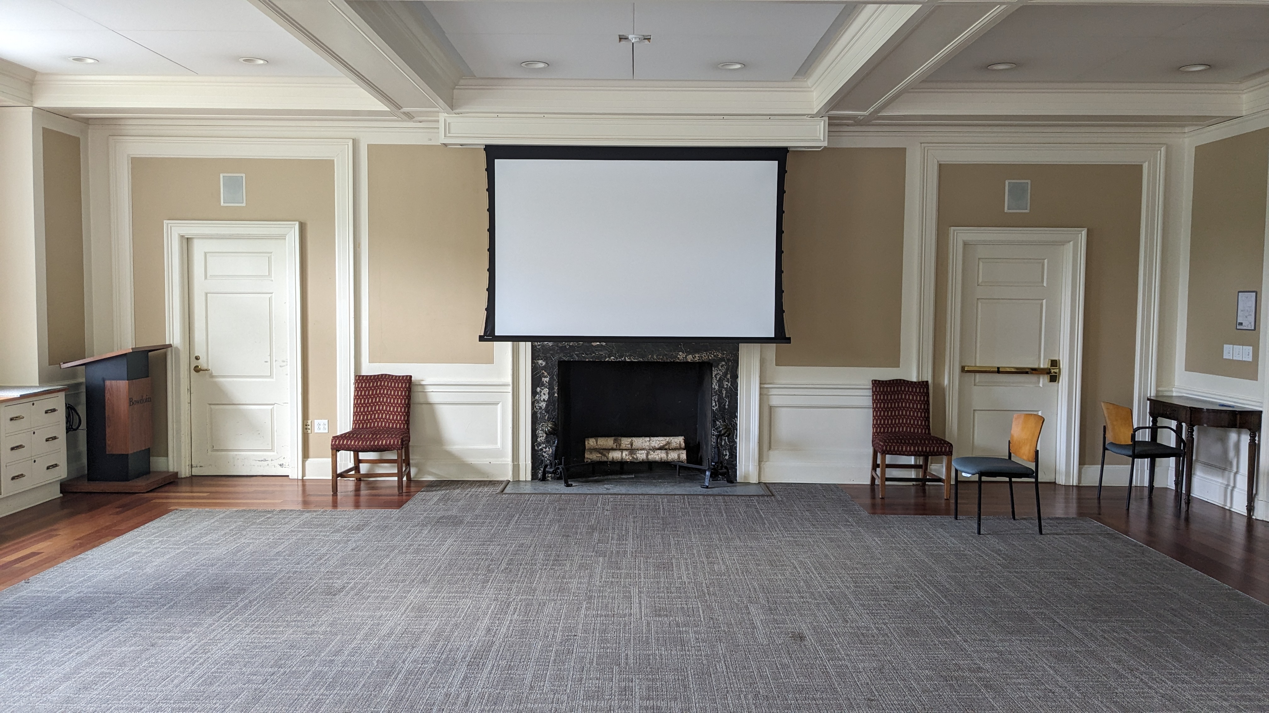 Small fireplace with projection screen in new england style room with elegant molding