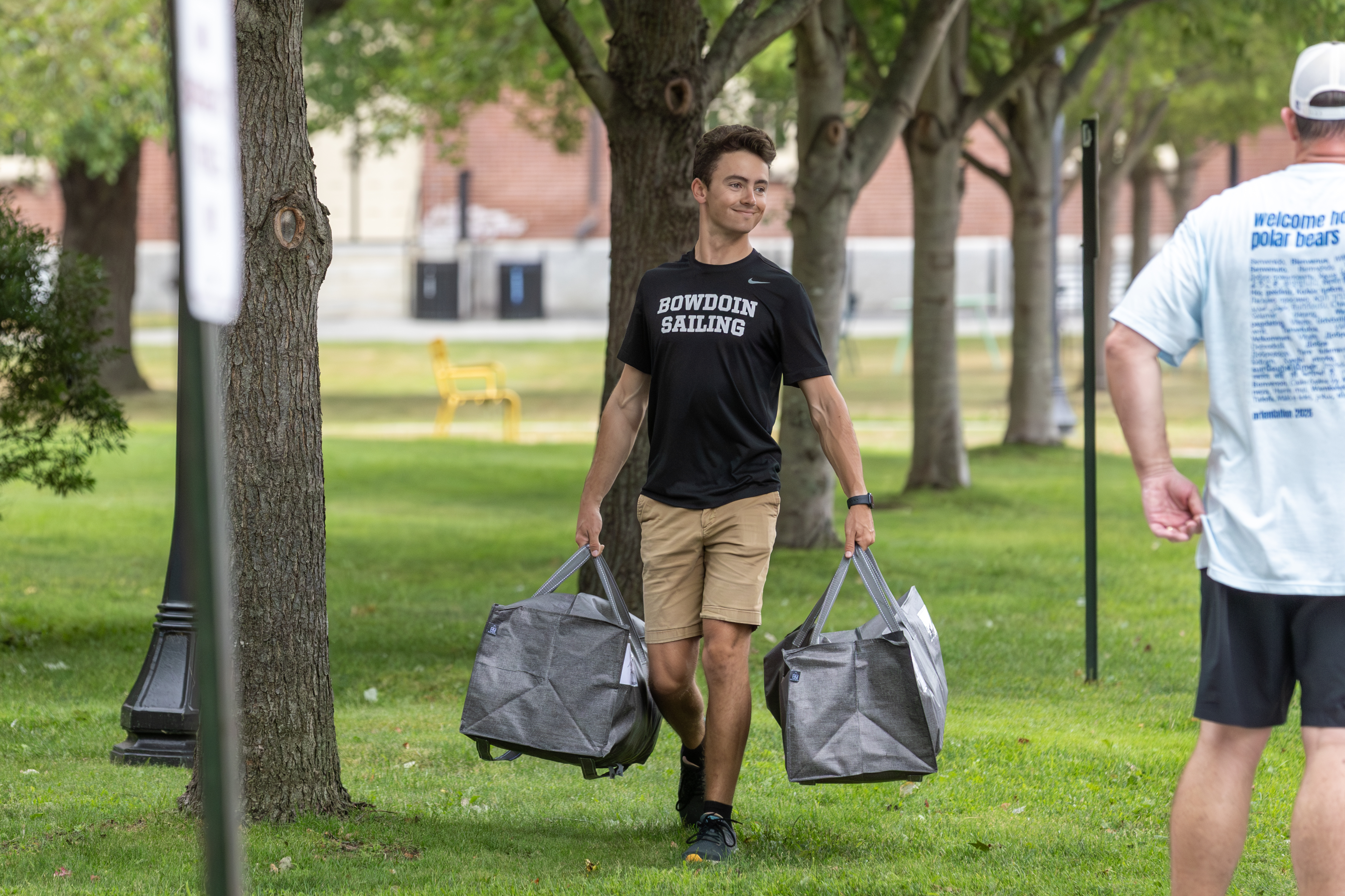 Bowdoin student helping carry bags