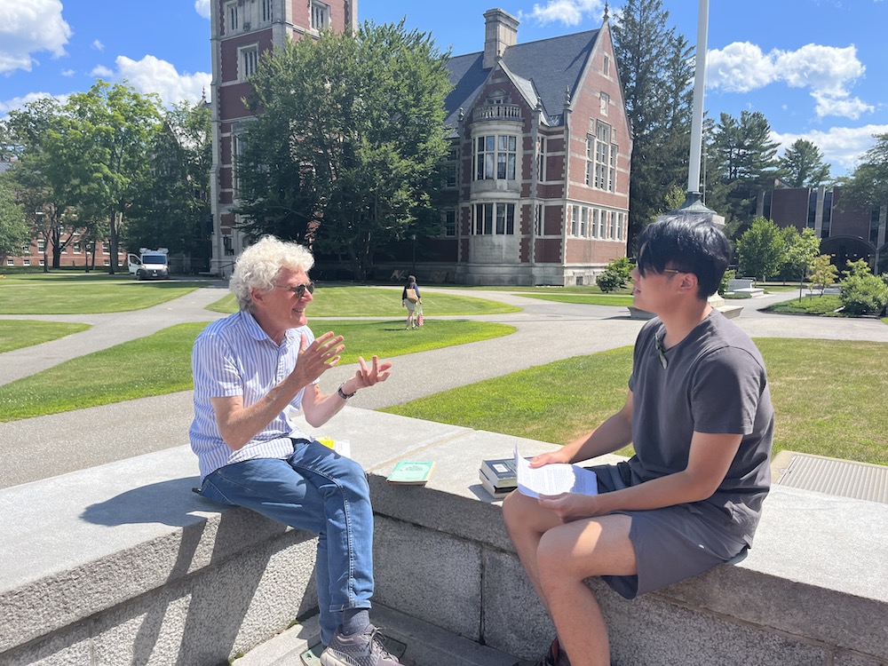Professor Paul Franco and student Chengkai Gu sitting outside on campus